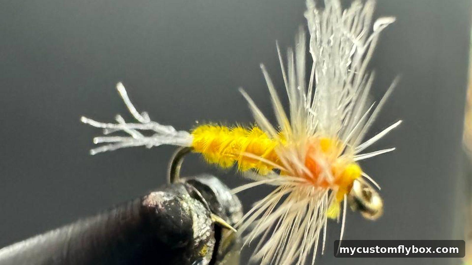 Yellow and orange dry fly held in a fly-tying vise