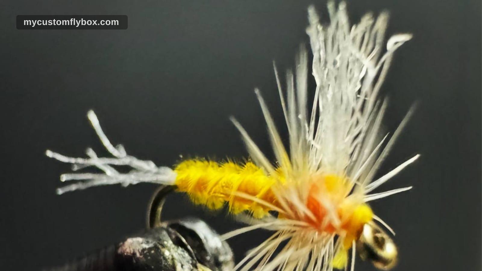 Close-up of a yellow sulphur dry fly tied in a vise