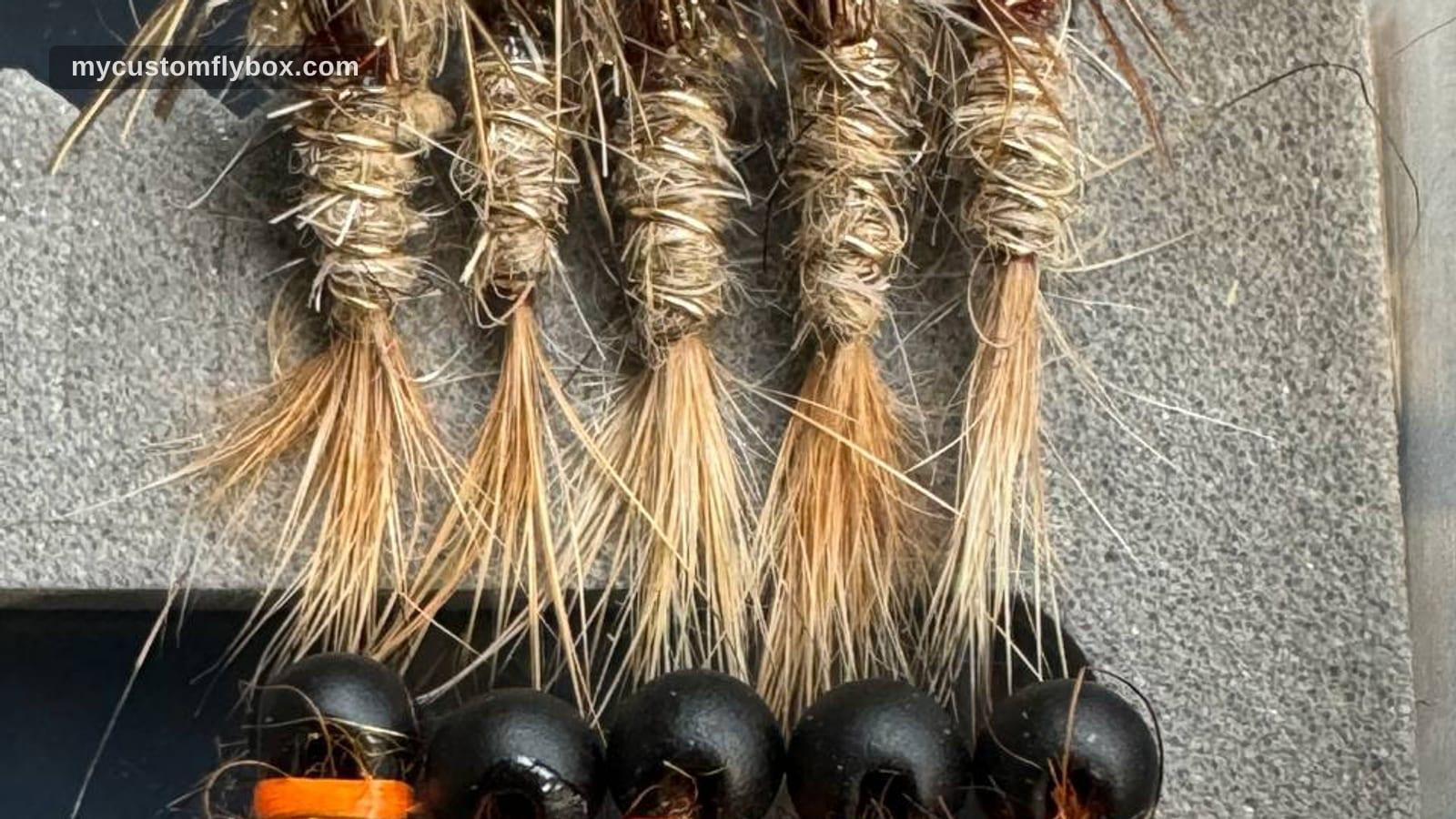 Rows of hand-tied trout nymphs arranged in a fly box